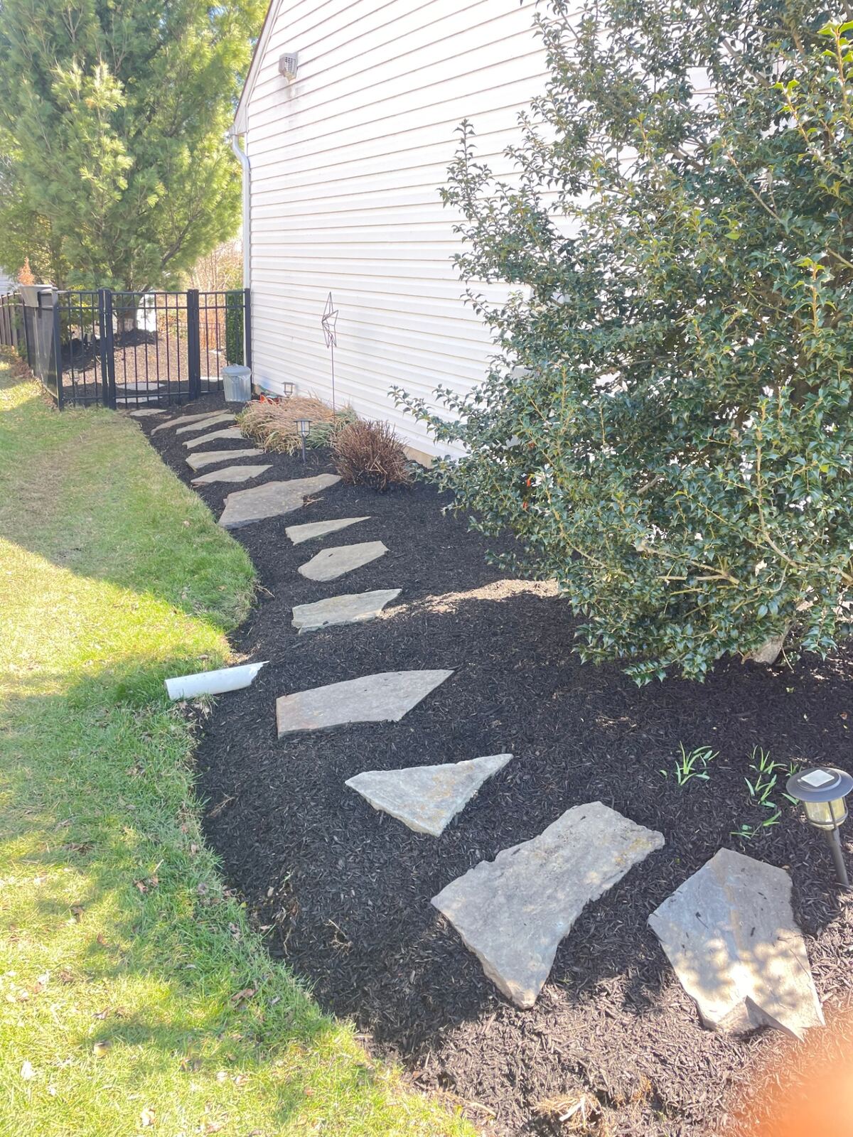 Flagstone walkway through freshly mulched side garden